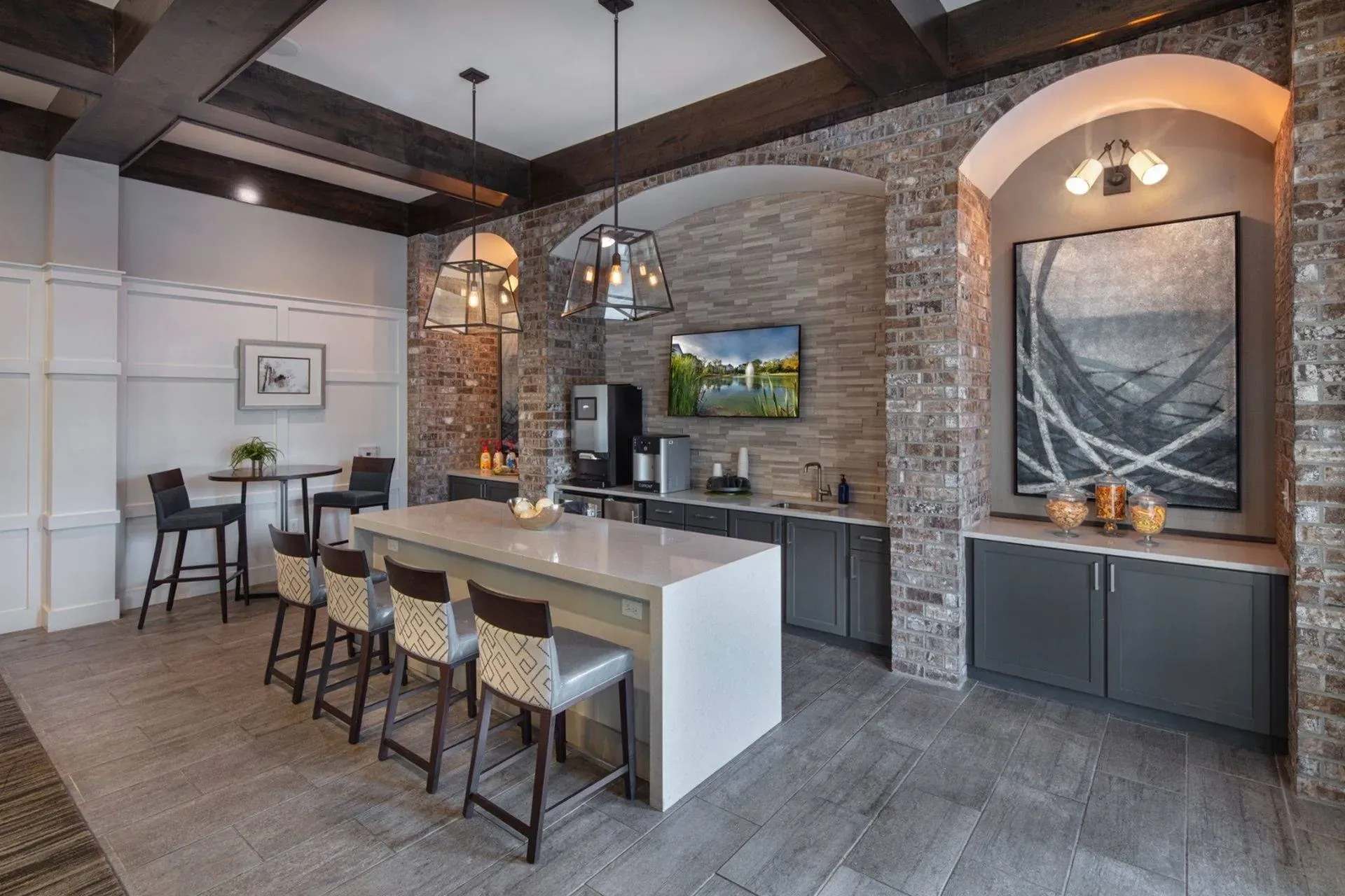 Vestavia Reserve Modern kitchen with brick accents, large island with bar stools, pendant lights, and a wall-mounted TV above the counter.