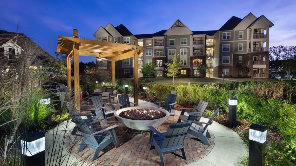 Vestavia Reserve Residential community entrance at dusk with path, manicured lawn, and vibrant sunset sky.